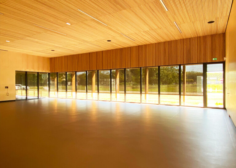 Habillage bois sur mesure pour un gymnase scolaire : Domarine & la Menuiserie Sibold relèvent le défi